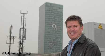 Генеральный директор Telefónica в Германии Рене Шустер рядом с LTE-антенной экспериментальной сети на фоне штаб-квартиры O2 в Мюнхене.